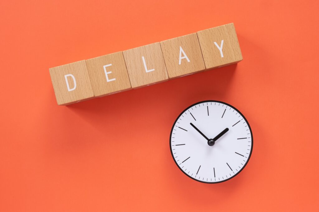 遅れ、遅延|「DELAY」と書かれた積み木と時計