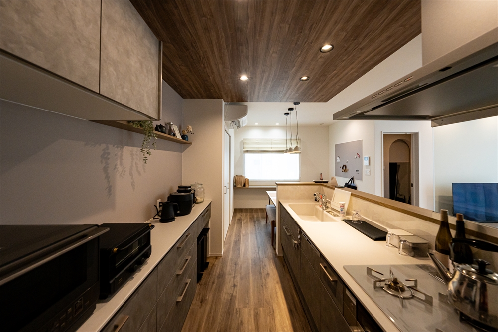 木目調の天井とダウンライトが印象的な、モダンキッチン事例。
