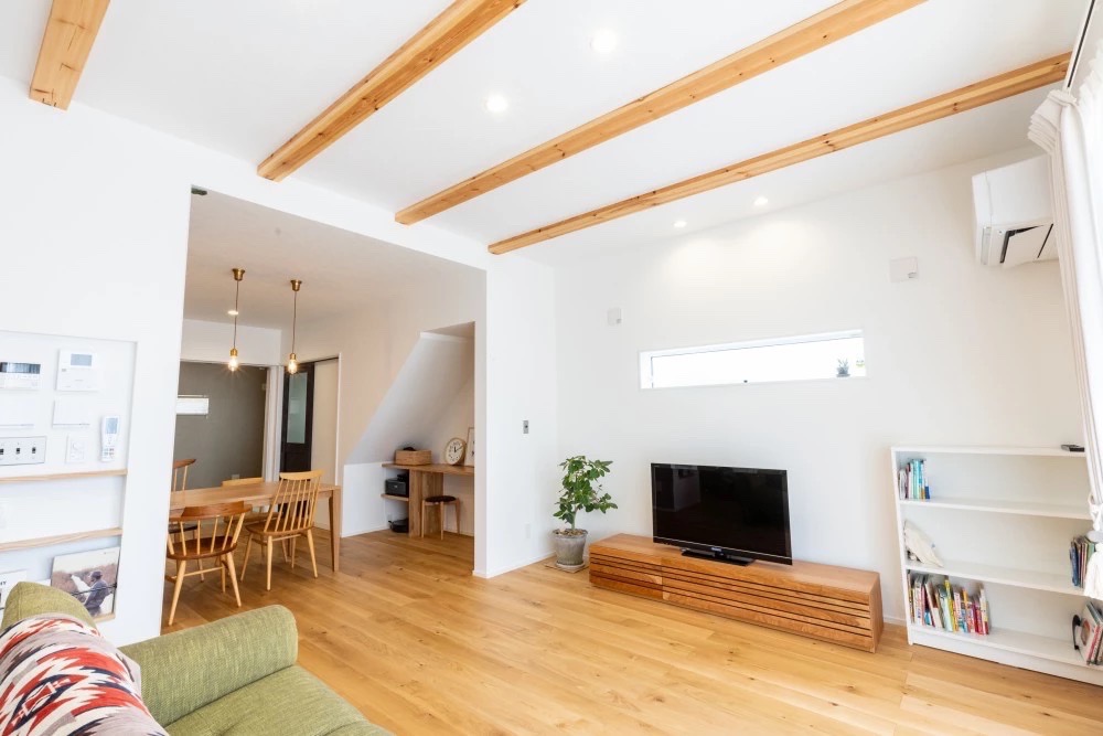 明るい木目のフローリングと白い壁が広がる、開放的なリビングダイニング。