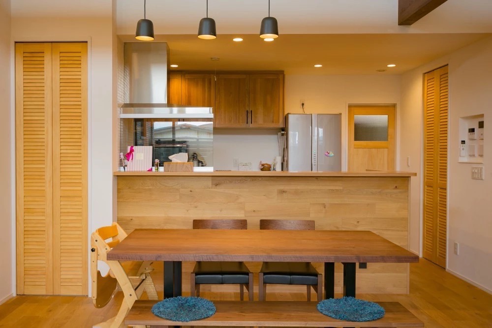 木目調のカウンターキッチンとダイニングテーブルが一体となった、施工事例。
